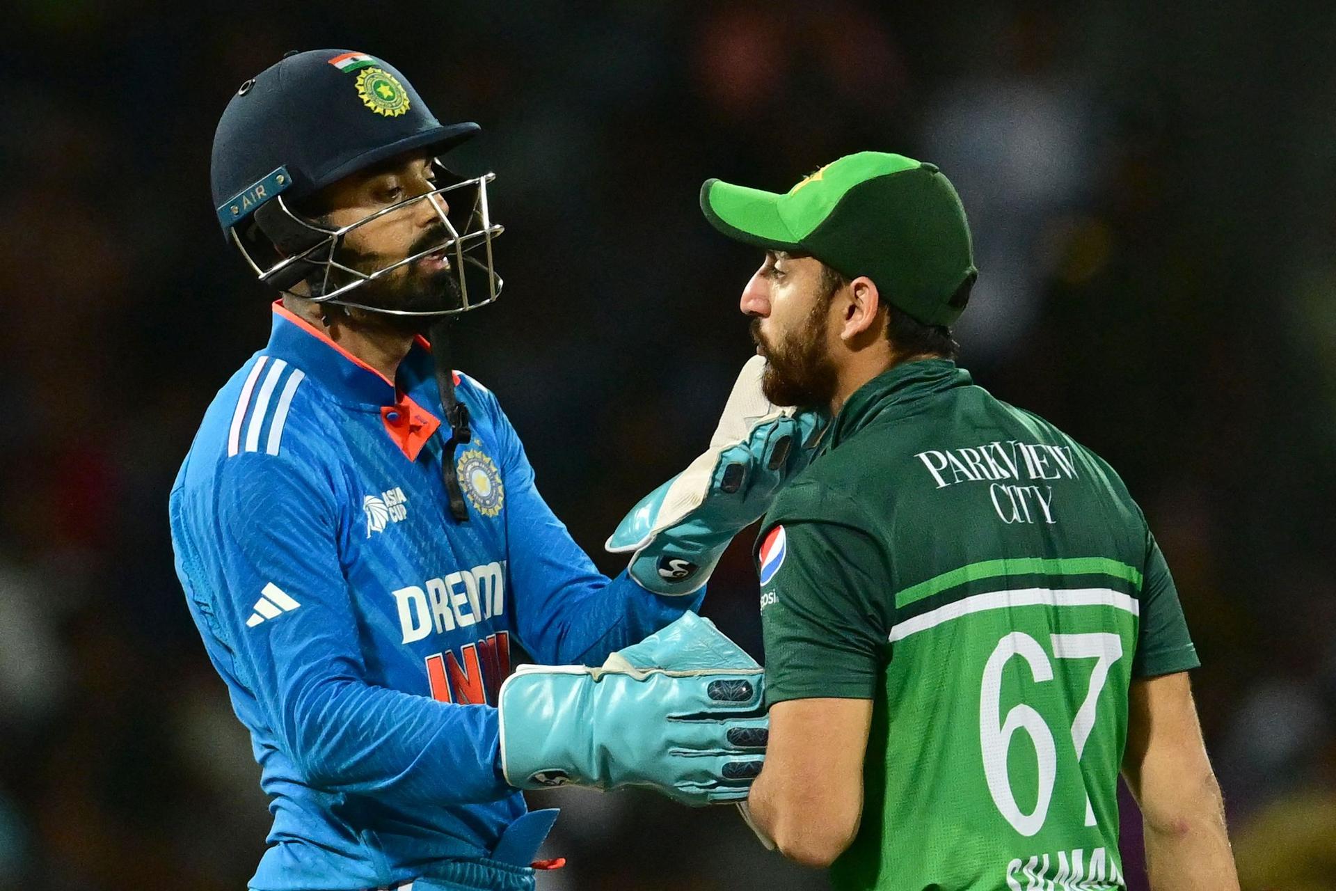 India's KL Rahul (L) checks the face of Pakistan's Agha Salman 