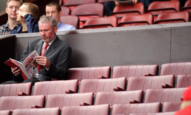 Brian McClair of Manchester United reads his United Review 